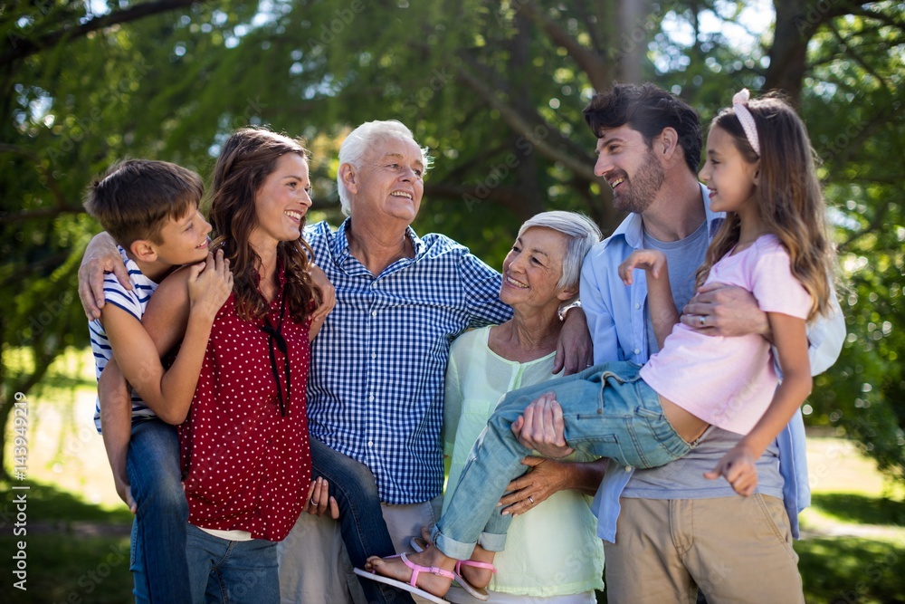 Smiling family posing together in park Smiling family posing together in park