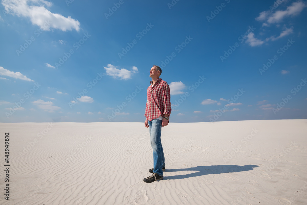 Joyful man stands in desert enjoying the cool wind and tranquility Joyful man stands in desert enjoying the cool wind and tranquility