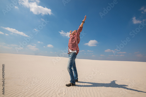 Happy man, traveler with open arms enjoying amazing world in desert