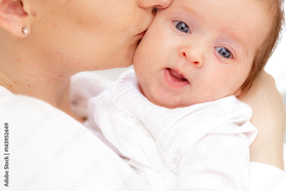 Young mother and newborn baby in white bedroom
