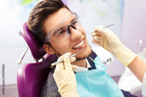 Portrait of male. smile face. Dental care Concept. Dental inspection is being given to Beautiful man surrounded by dentist and his assistant  