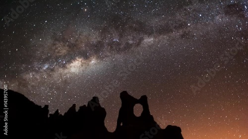 Static timelapse astrolapse at night of scorpius in the Milky Way and the moon rising over an eroded landscape, in the Southern Hemisphere available on request.