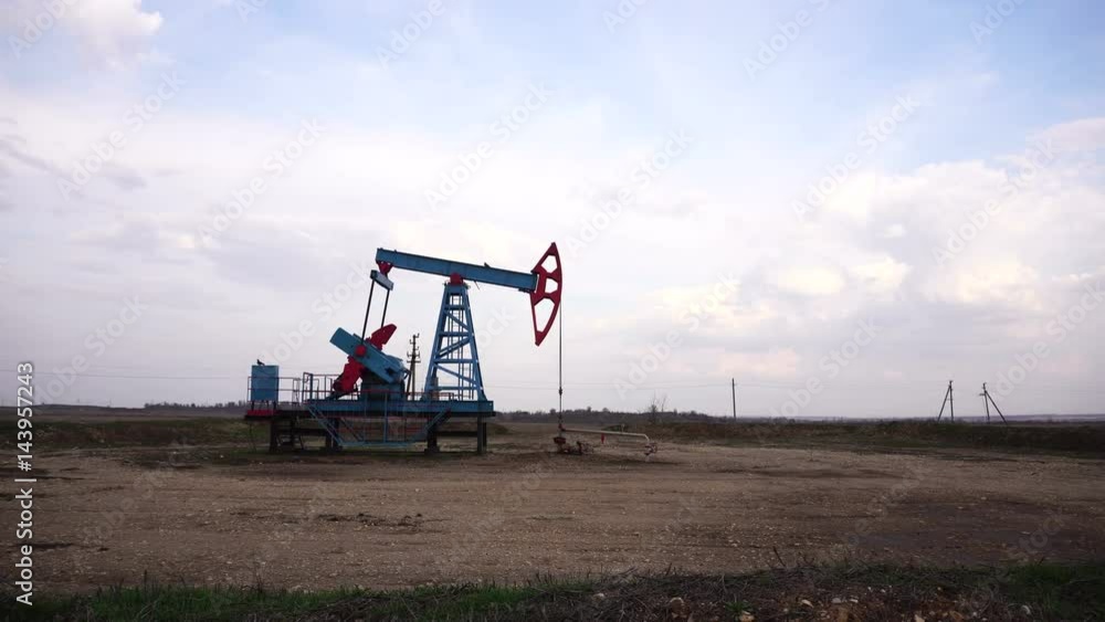 Working oil well. Cloudy sky. Working oil well. Cloudy sky.