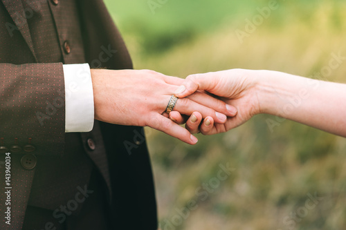 Loving couple holding hands with rings against wedding dress © jul14ka