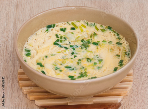 steamed eggs sprinkled with onions in a brown bowl