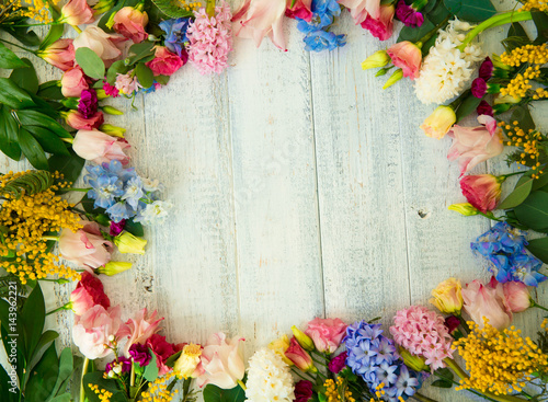 Spring flowers on wood background. Summer blooming border on a wooden table.