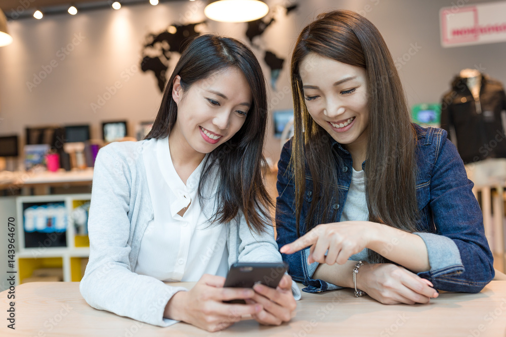 Happy women looking at mobile phone together Happy women looking at mobile phone together