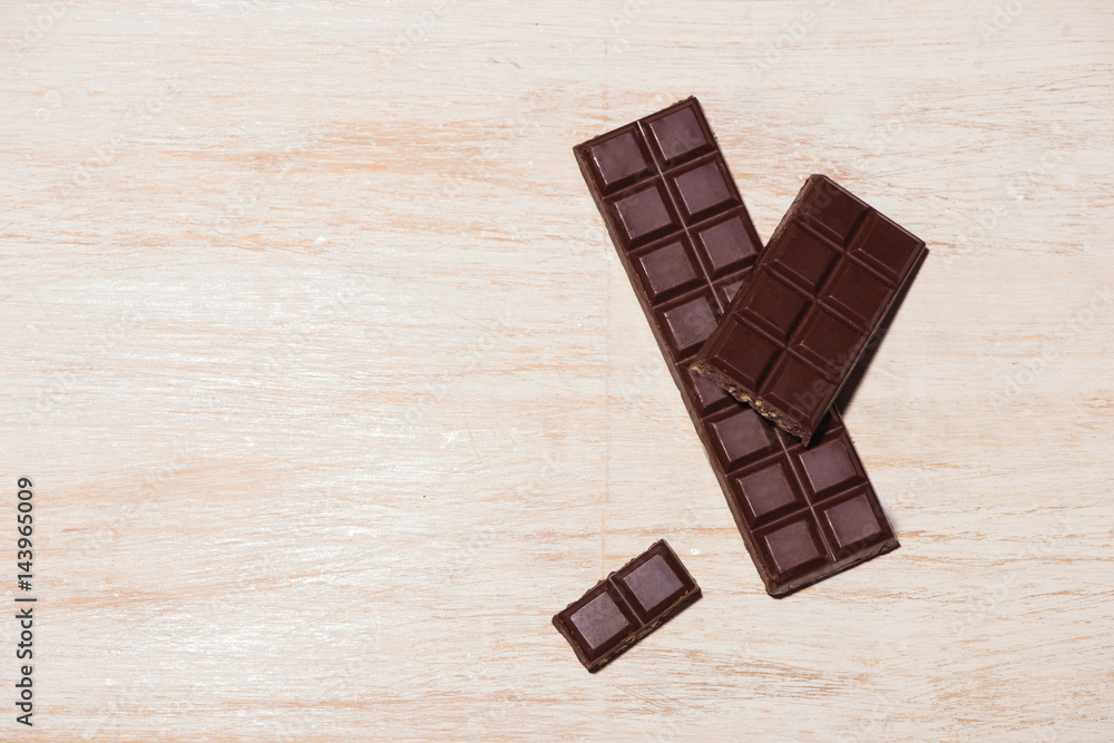 Chocolates bar in box on white wooden background Chocolates bar in box on white wooden background