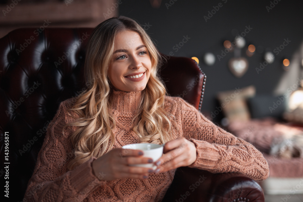 Woman with drink in armchair Woman with drink in armchair