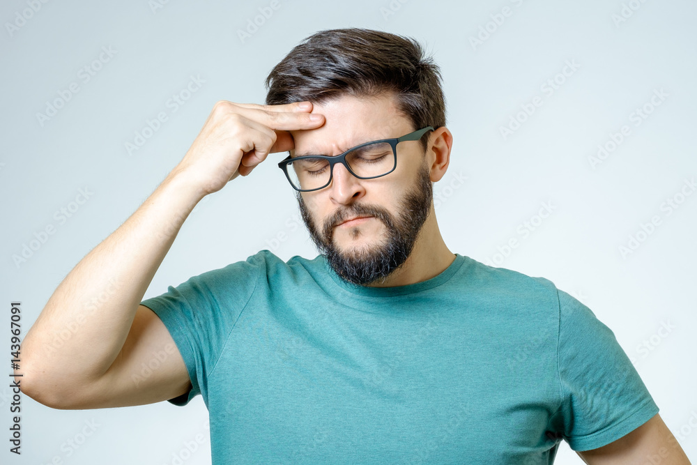 Depressed handsome bearded man touching having a headache Depressed handsome bearded man touching having a headache