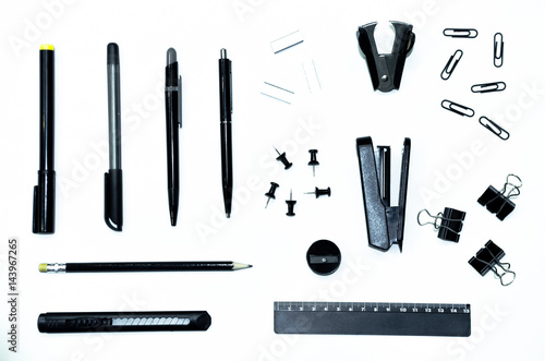 Obraz na płótnie Black pen, pencil, ruler, stapler, stationery knife, paper clips, clamps, sharpener, corrector and hole punch isolated on white background