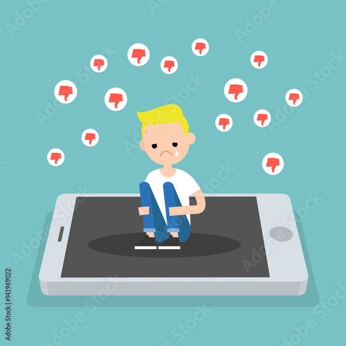 Upset crying blond boy sitting on the mobile's screen and hugging his knees surrounded by the dislike symbols / editable flat vector illustration, clip art
