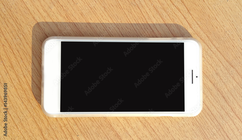 Modern mobile smart phone with black screen for mockup On a wooden table . Modern mobile smart phone with black screen for mockup On a wooden table .
