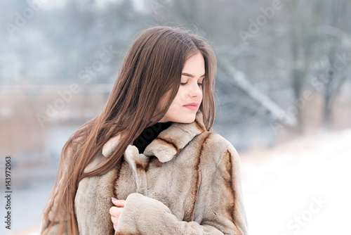Teenager girl in the snow with fur coat