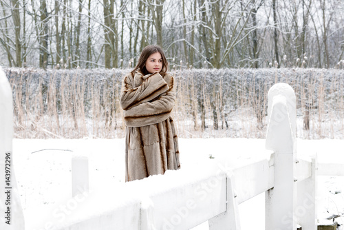 Teenager girl in the snow with fur coat