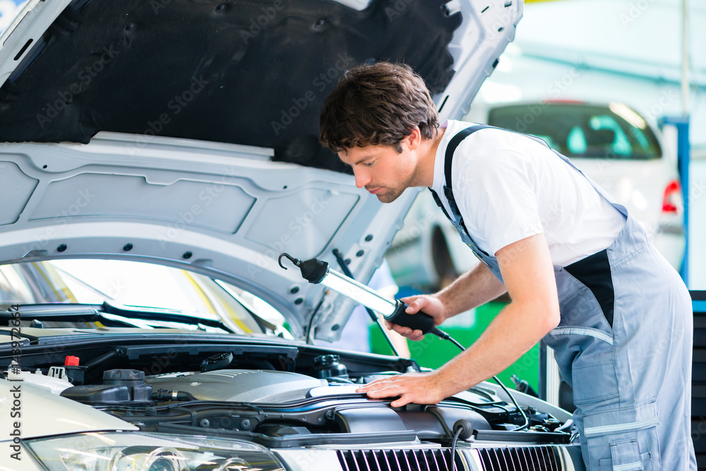 KFZ-Mechaniker arbeitet mit Werkzeug in Autowerkstatt KFZ-Mechaniker arbeitet mit Werkzeug in Autowerkstatt