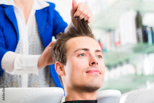 Friseur schneidet Mann die Haare im Herrensalon