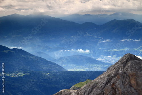 Haze, clouds and sun rays over Pokljuka Plateau, Bohinj Valley, Bohinj Group, Slovenian Prealps and the close peak Miseljski Konec, from Kanjavec, Julian Alps, Triglav National Park, Slovenia