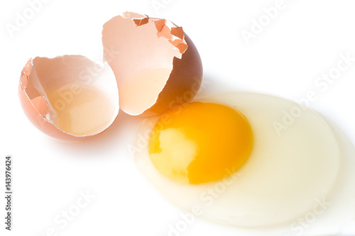 A broken chicken egg lies on a white background with a shell, yolk and spilled protein, isolated
