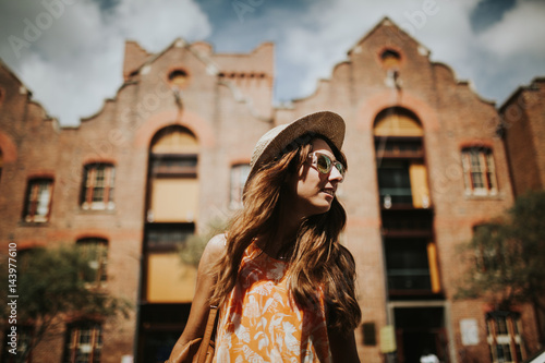 Cute woman in sunglasses with city buildings in the background, in Sydney, Australia.