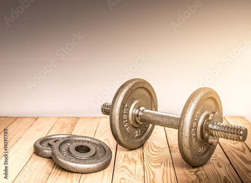 Dumbbells , weight plates on wooden background for bodybuilder. Concept for sport player or workout. gym of accessories for fitness