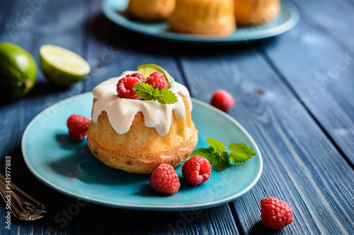 Mini lime bundt cakes with whipped cream and raspberries topping