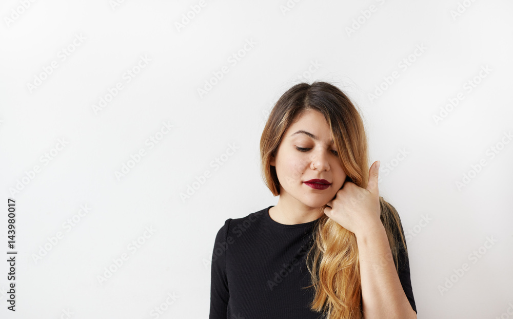 Portrait of pretty girl dreamy thinking about thinking about the upcoming SPA looking down touching her long hair. Beautiful plus size girl likes beauty treatments in salons. Beauty industry concept Portrait of pretty girl dreamy thinking about thinking about the upcoming SPA looking down touching her long hair. Beautiful plus size girl likes beauty treatments in salons. Beauty industry concept