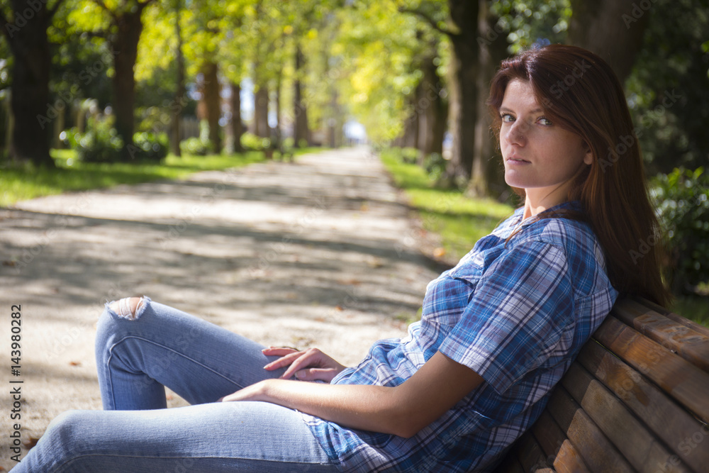 Beautiful young woman in casual dress sitting on the bench Beautiful young woman in casual dress sitting on the bench