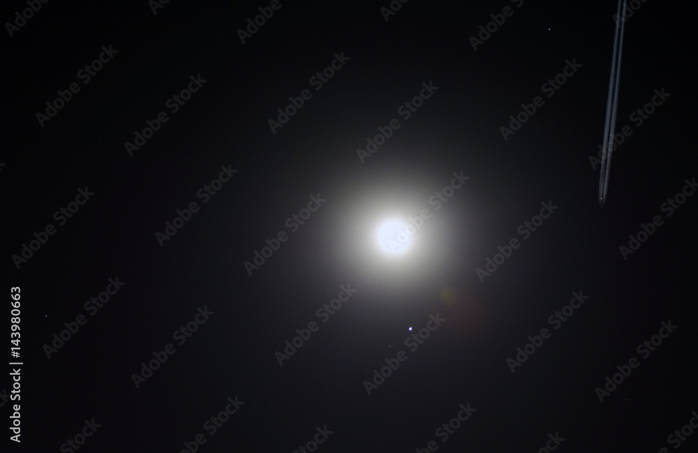 The Full Moon rotating next to Jupiter and an airplane leaving a trail The Full Moon rotating next to Jupiter and an airplane leaving a trail