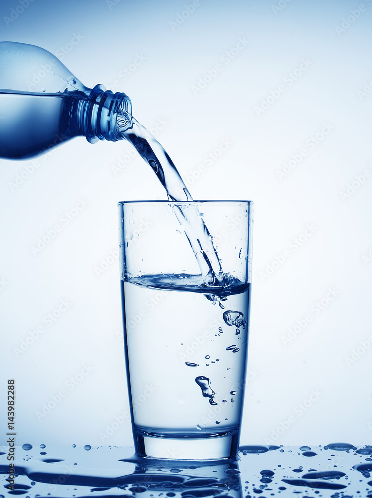 Water flowing from bottle into a glass Water flowing from bottle into a glass