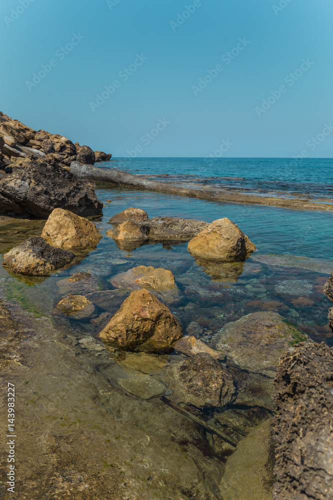  Beautiful scenery on the shores of the Mediterranean Sea in North Cyprus. Rocky shore of the northern sea. Sunny day in Cyprus. Calm sea.