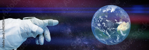 Fototapeta Naklejka Na Ścianę i Meble -  astronaut pointing to planet Earth in front of the Milky Way galaxy