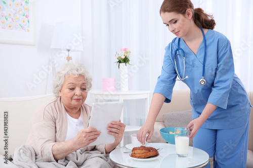 Nurse helping elderly woman...