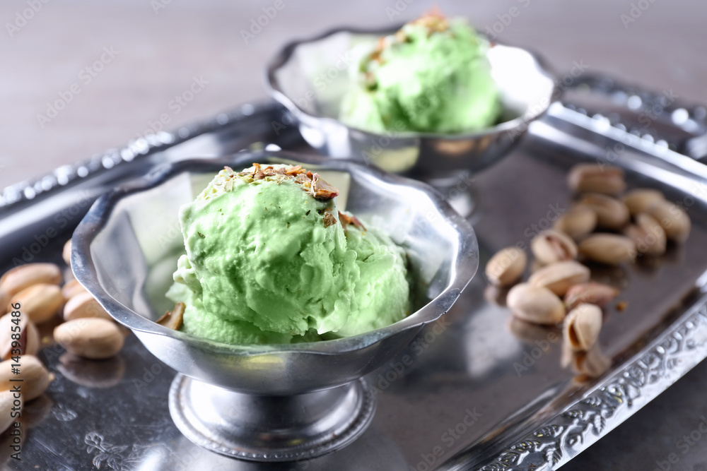 Dessert bowls with delicious pistachio ice cream on metal tray Dessert bowls with delicious pistachio ice cream on metal tray