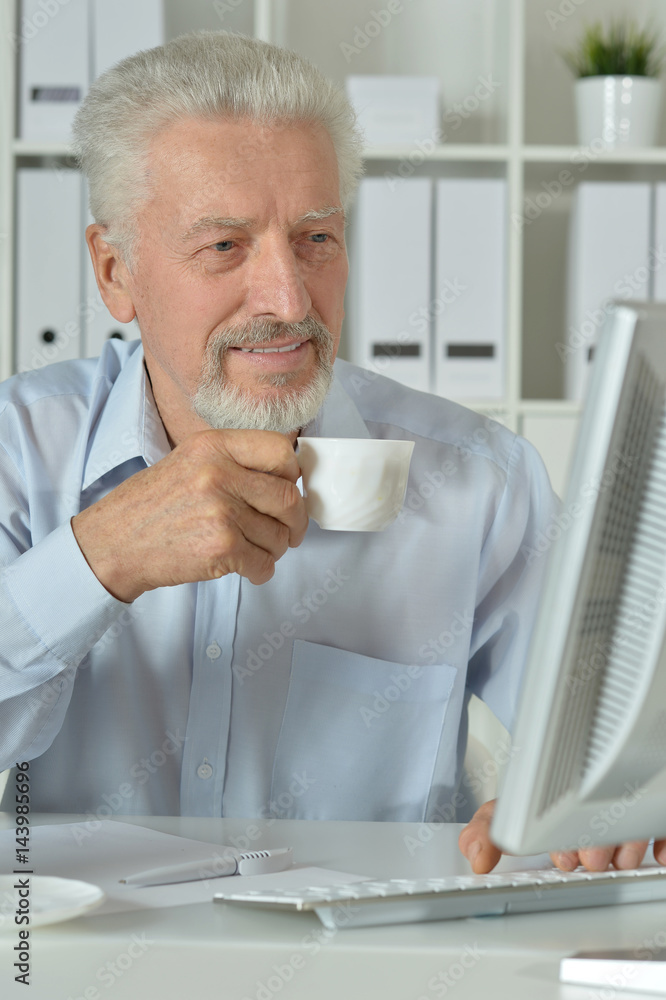Old businessman with a laptop working Old businessman with a laptop working