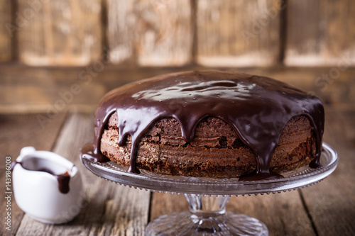 Homemade chocolate cake on glass cakestand photo