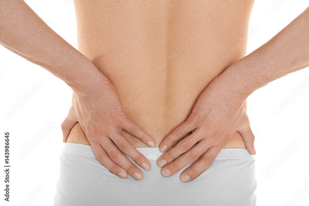 Young man suffering from back pain on white background, closeup