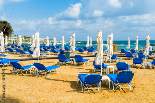 blue sunbeds on the beach © Andrey