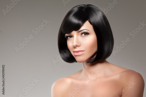 Stylish woman with a bob hairstyle. Girl model with a short black fringe and vlosami.