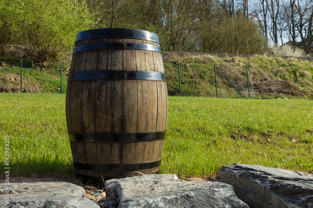 Barrel on the left with a green lawn and trees on the background Barrel on the left with a green lawn and trees on the background