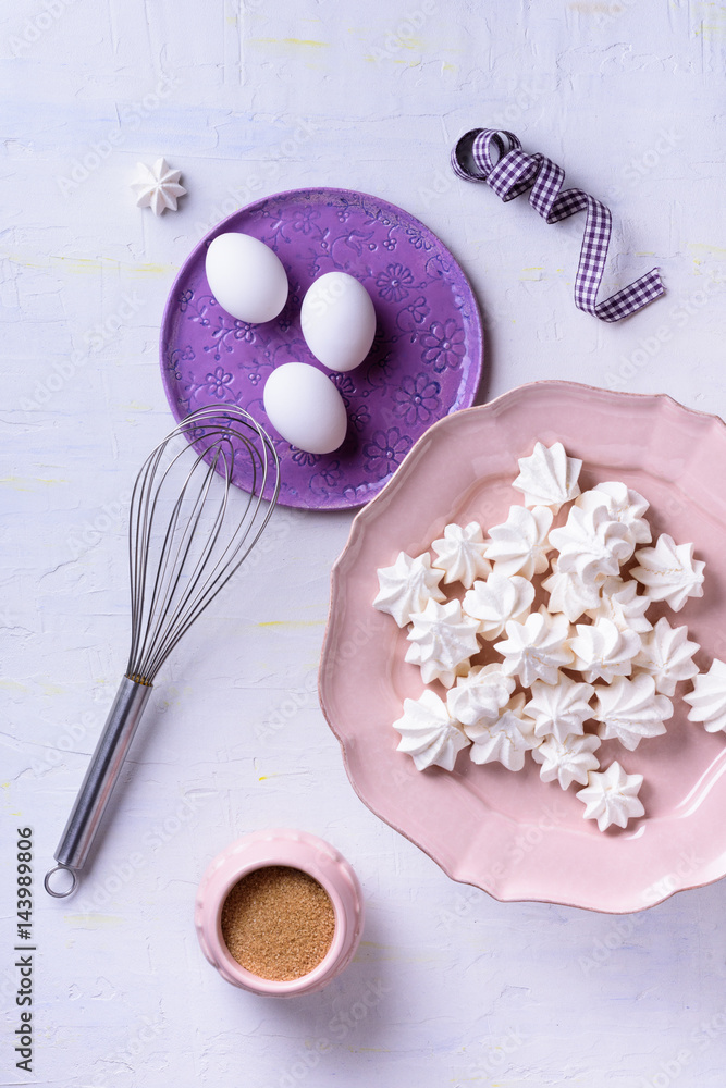Meringues on pink plate. Many sweet zephyrs on white background. Top view dessert. Bakery products background, sweet dessert. Meringues on pink plate. Many sweet zephyrs on white background. Top view dessert. Bakery products background, sweet dessert.