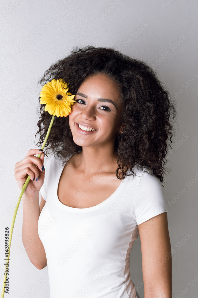 Attractive female model holding gerbera, studio shot Attractive female model holding gerbera, studio shot