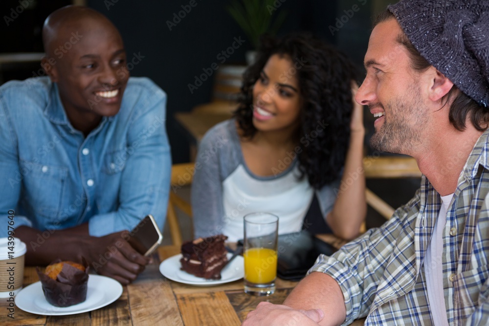 Man talking with friends at table in coffee house Man talking with friends at table in coffee house