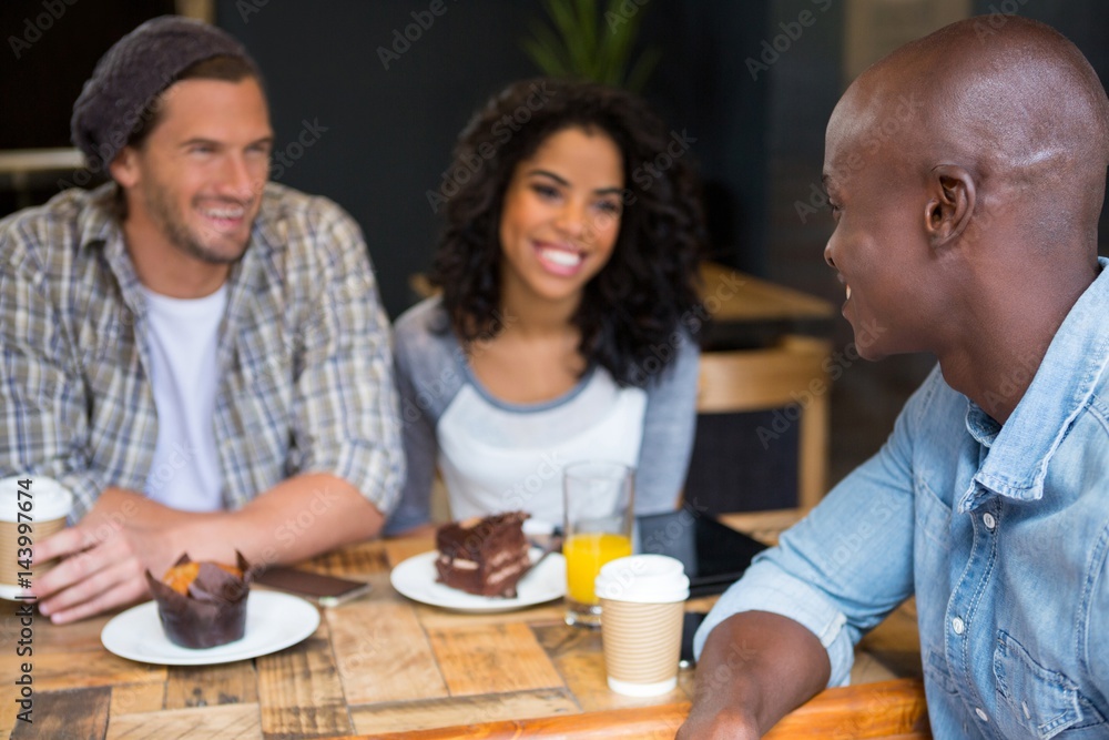 Man talking with friends at table in coffee shop Man talking with friends at table in coffee shop