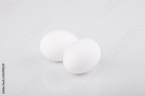 Two white eggs on a white surface. Isolated on white background.