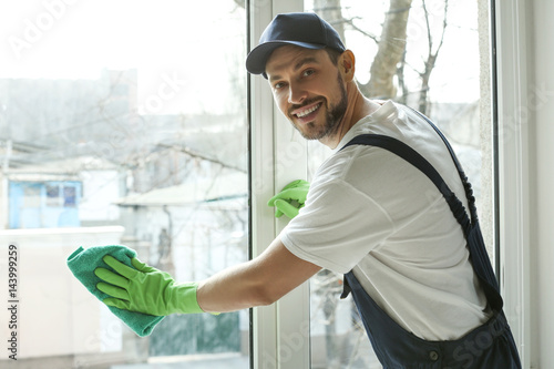 Young man cleaning window i...