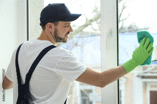 Young man cleaning window i...
