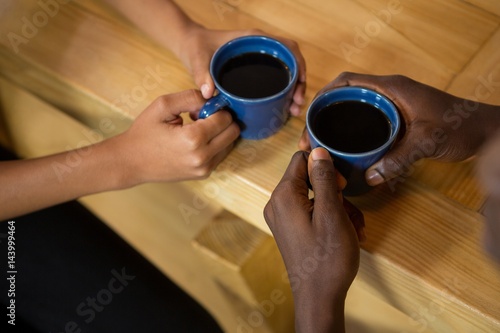 Couple hands holding coffee cups at table