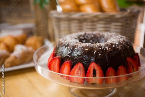 Bundt cake surrounded by strawberries in coffee house
