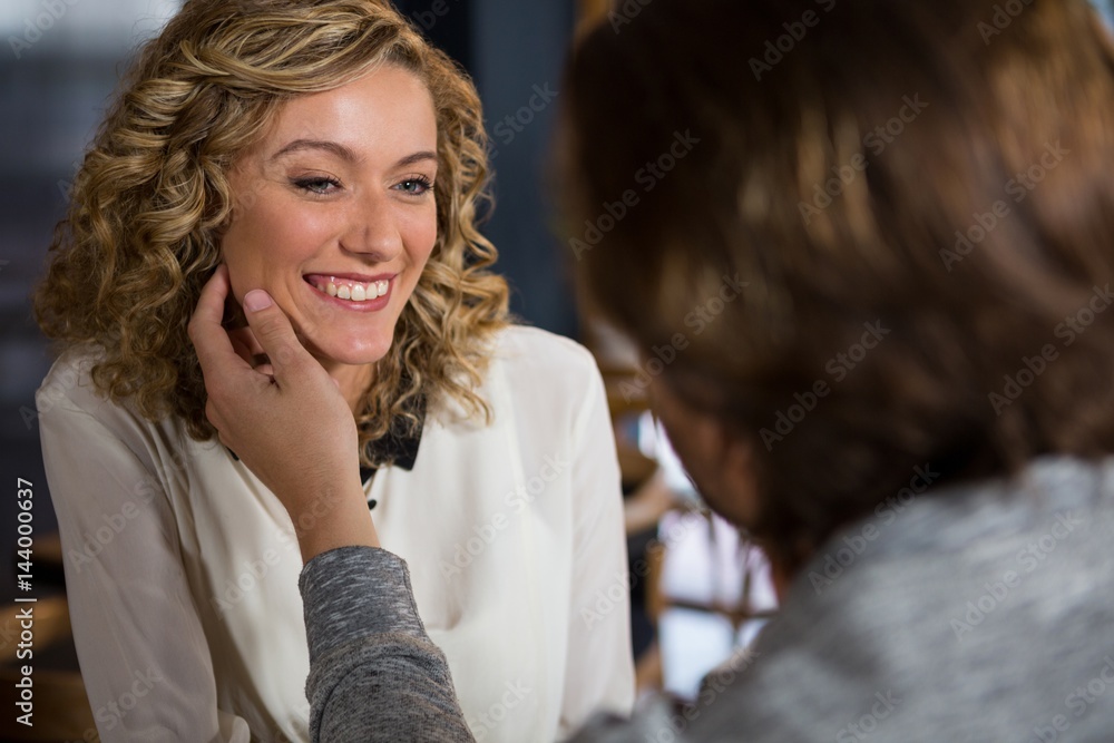 Fototapeta premium Man touching womans face in coffee shop